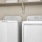 a white washing machine and a white shelf